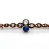 An antique gold brooch set with diamonds in an old polish and a natural sapphire