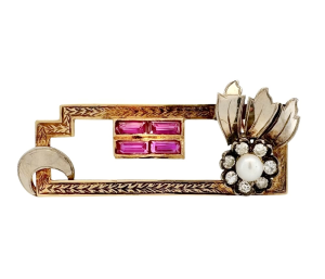 A gold brooch with a unique geometric design studded with diamonds, rubies and pearls