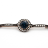 An antique gold brooch studded with diamonds and an impressive central sapphire stone